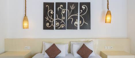 Ein Hotelzimmer mit einem Bett, zwei Nachttischen und einem an der Wand hängenden Kunstwerk über dem Bett.