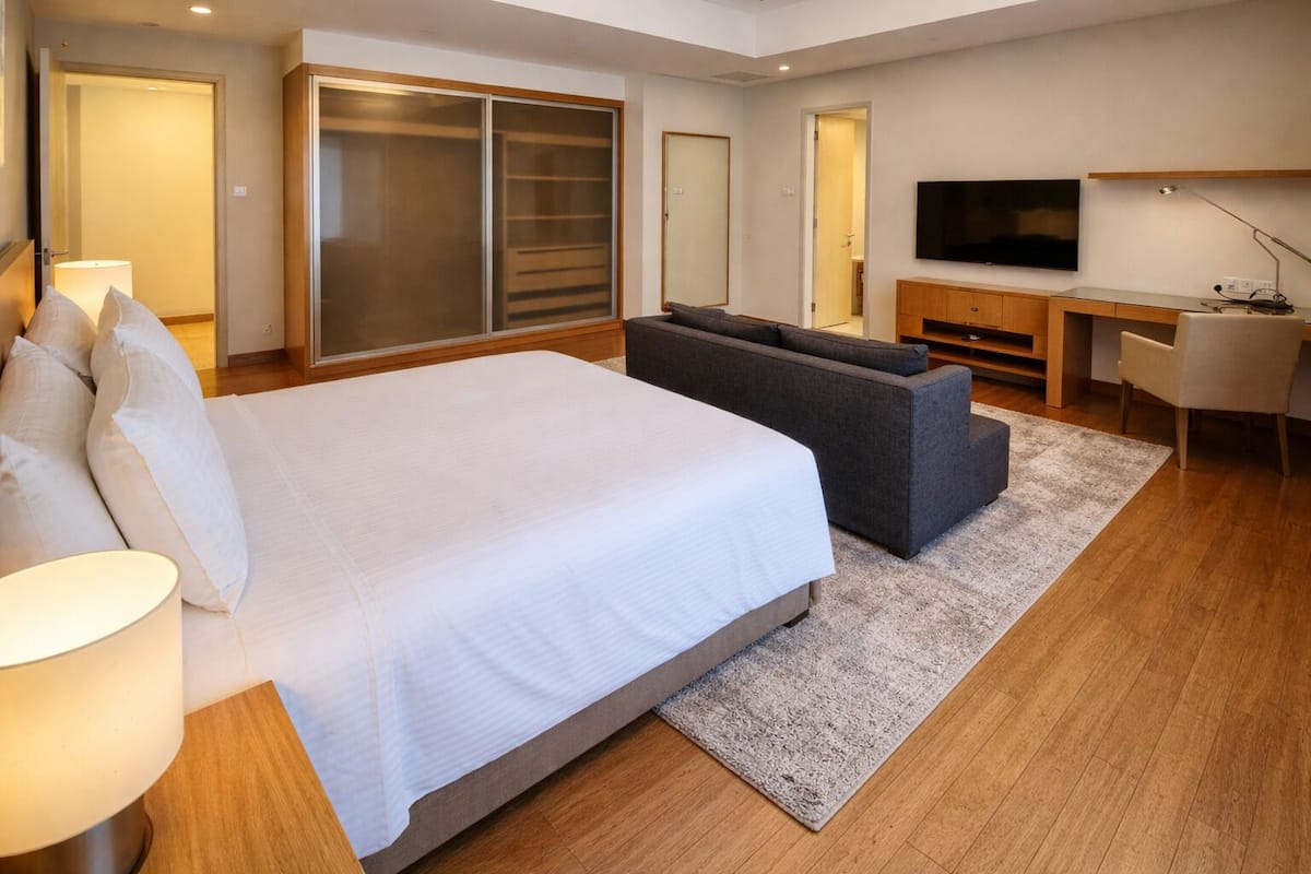 Une chambre d’hôtel moderne équipée d’un grand lit, d’un canapé, d’un bureau et d’une télévision.