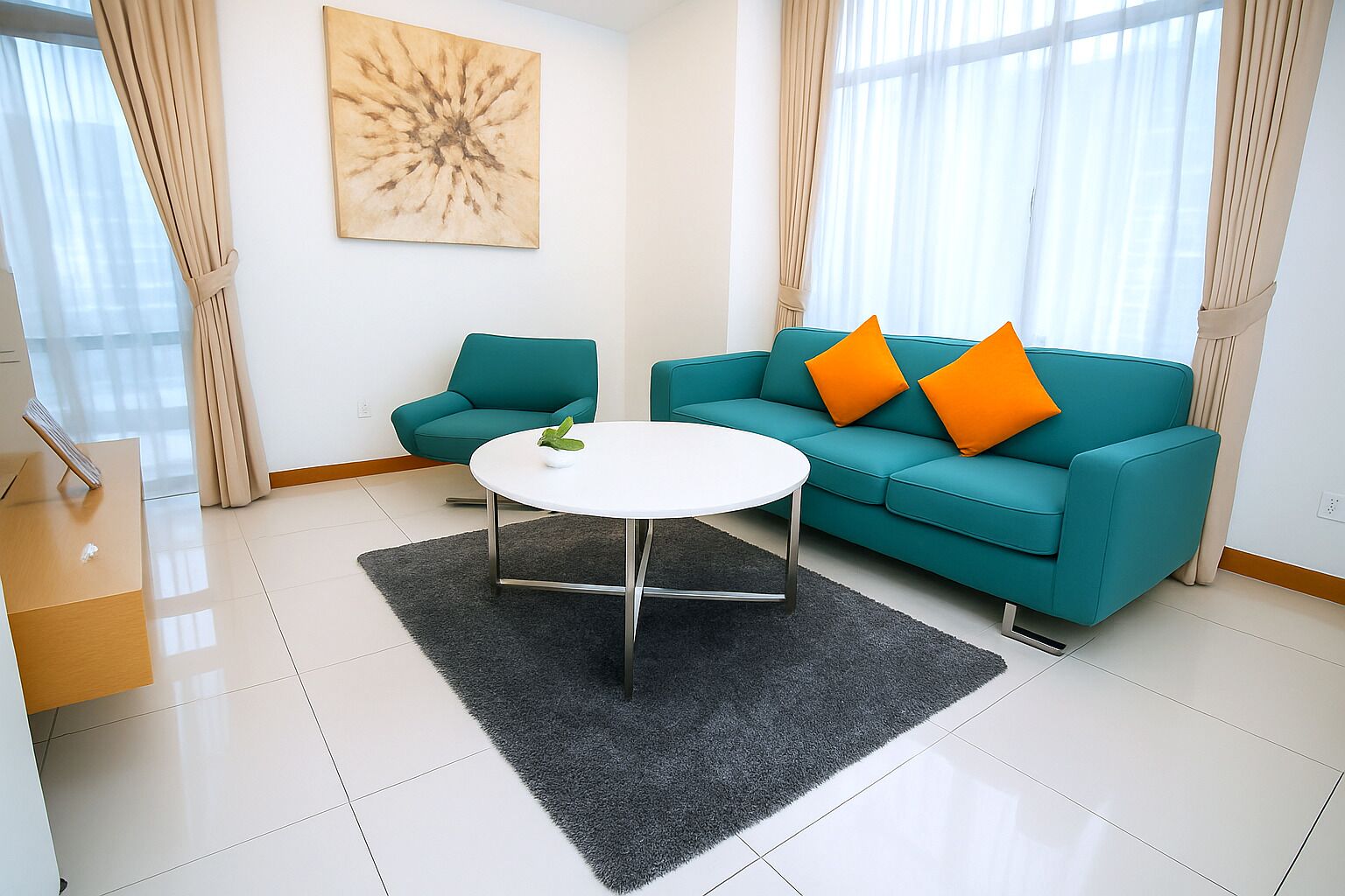 A modern living room with a teal sofa, two orange cushions, a white coffee table, and a black rug.