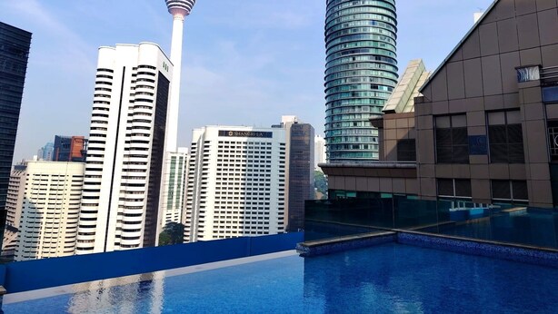 A modern urban skyline with high-rise buildings, including a distinctive tower with a spire. - Cormar Residences Kuala Lumpur (Kuala Lumpur)