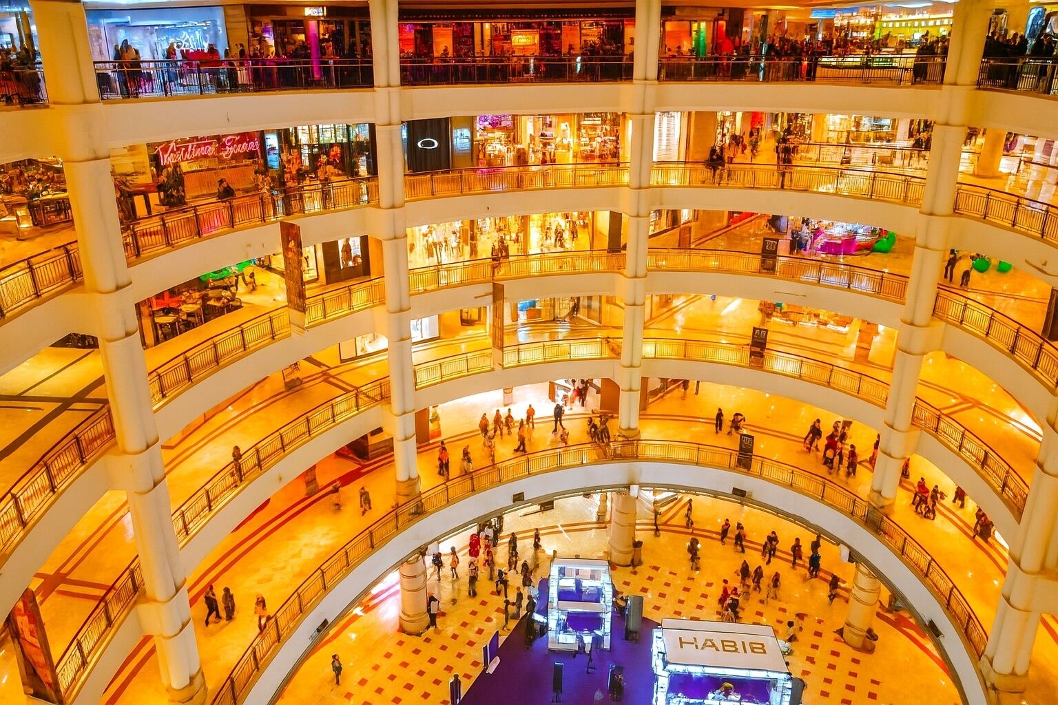 A multi-level shopping mall with several floors, escalators, and a central open area.