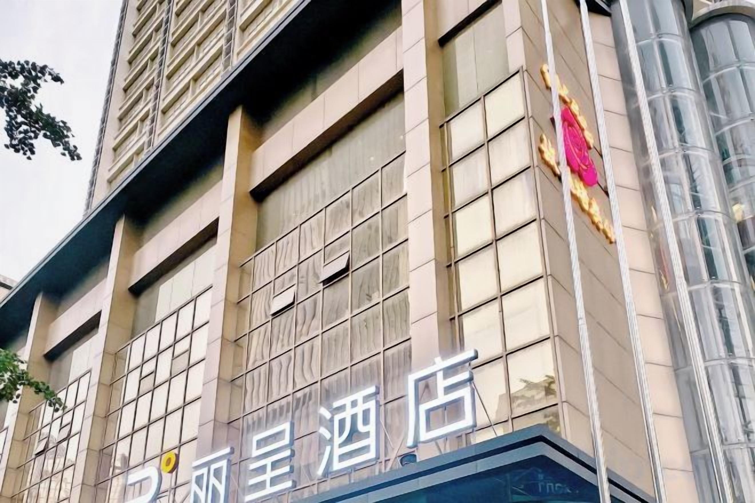 A hotel facade with large windows and a prominent sign.
