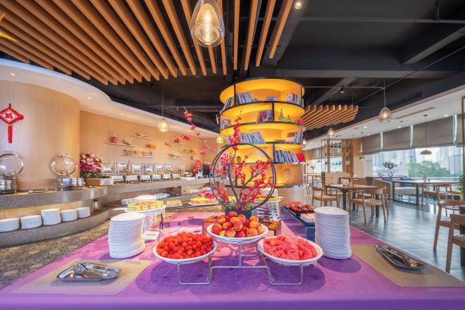 Montaje de bufé con varias estaciones de comida y una estructura decorativa central.
