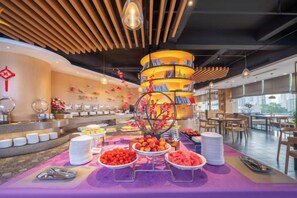 Un'attrezzatura per buffet con diverse postazioni gastronomiche e una struttura decorativa centrale.