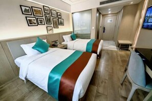 A hotel room with two beds, a desk, a chair, a TV, and framed pictures on the wall. - Wuhan Zhongshan Park Xuesong Road (Wuhan)