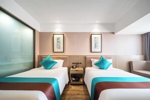 A hotel room with two beds, a nightstand, and artwork on the walls. - Wuhan Zhongshan Park Xuesong Road (Wuhan)
