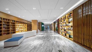 A modern library interior with marble flooring, wooden bookshelves, and a central seating area. - Wuhan Zhongshan Park Xuesong Road (Wuhan)