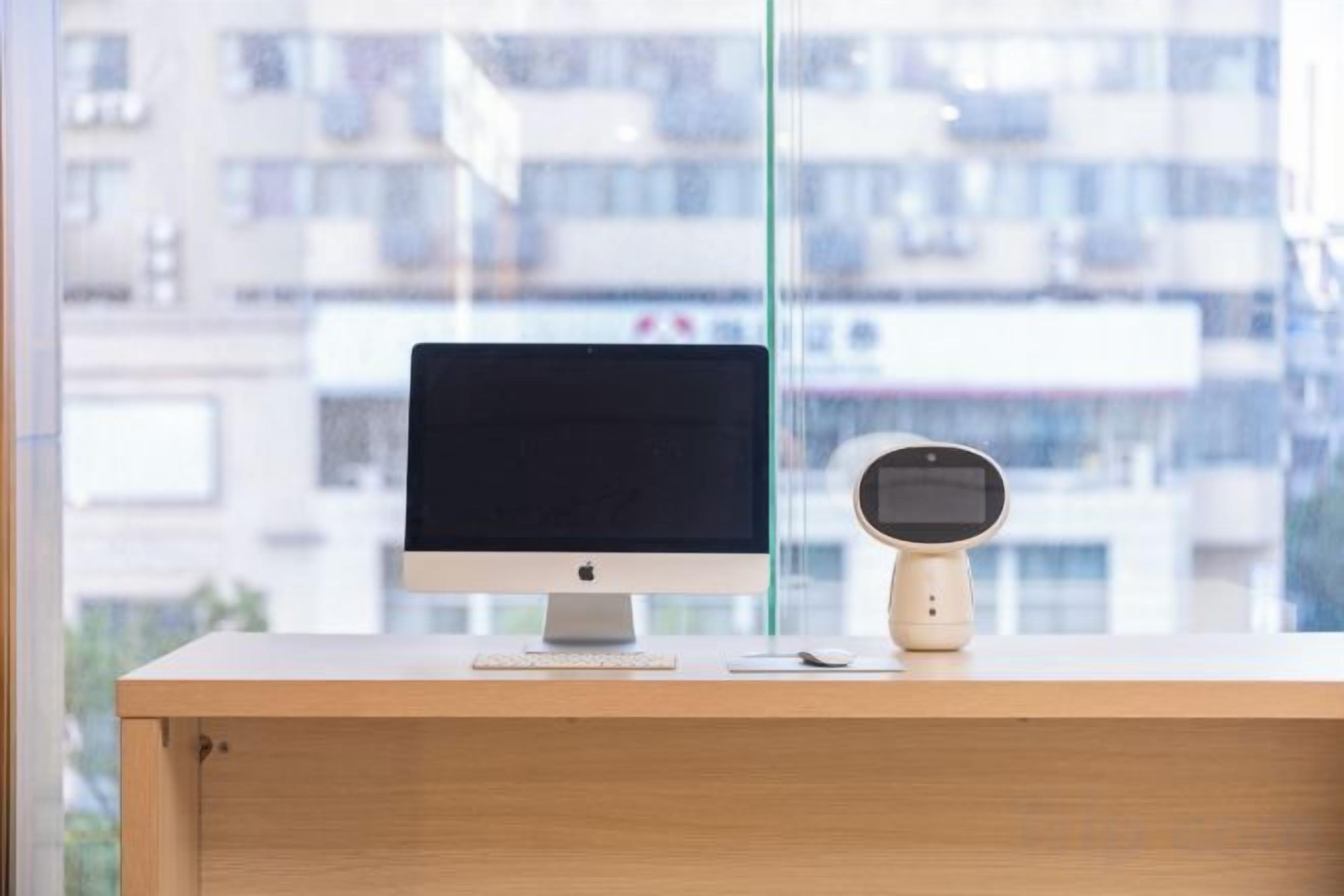 A desk with a computer monitor and a speaker.