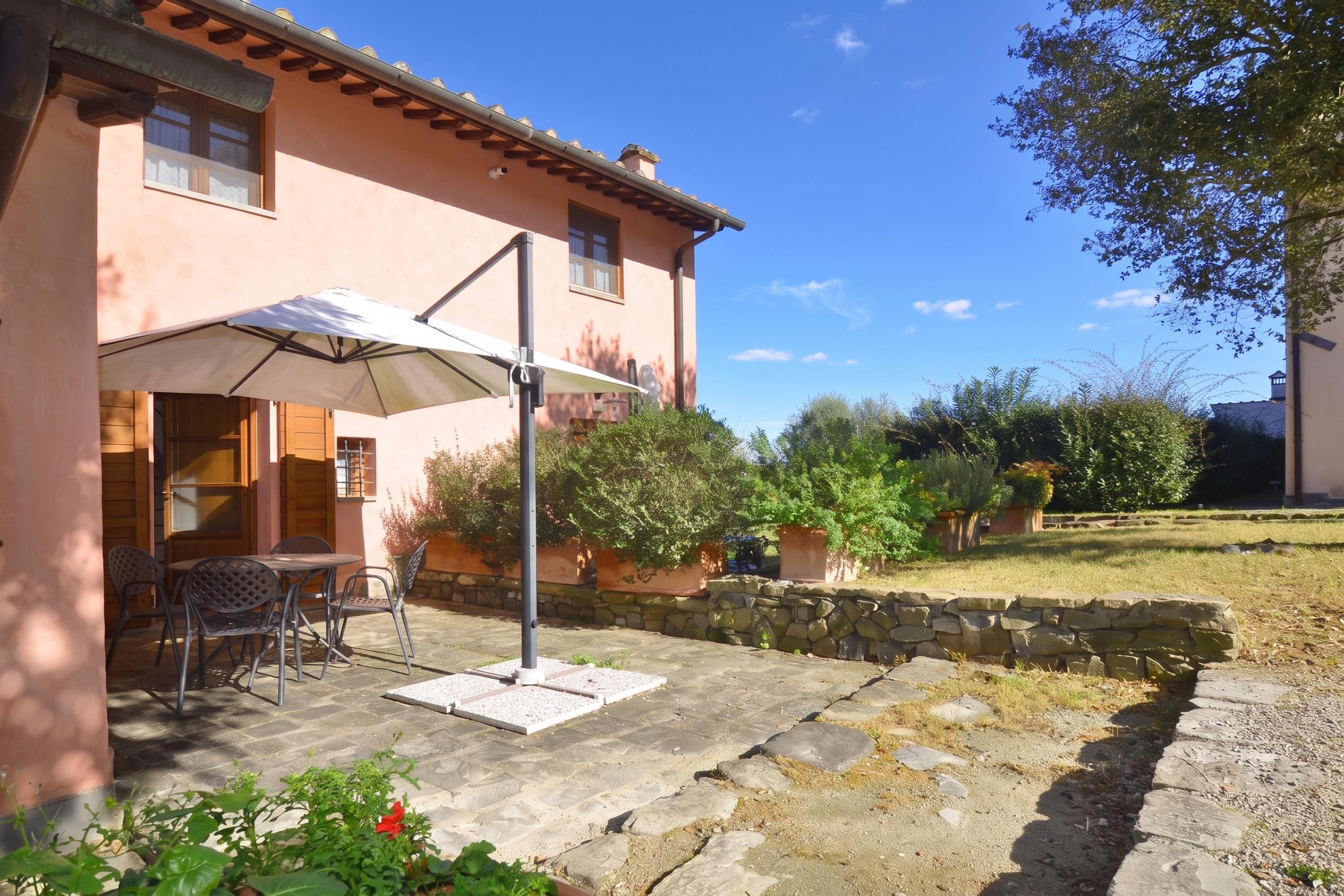 Une maison dotée d’un patio, de mobilier d’extérieur et d’une pergola offrant de l’ombre.