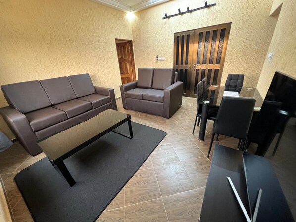 A living room with a sofa, a coffee table, and a TV stand.