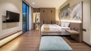 A modern bedroom with a large bed, a TV mounted on the wall, a desk, and a large abstract painting. - Villa Noema 2 - Brand New 2BR Villa with Pool (Badung)