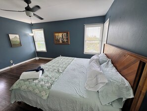 A bedroom with a bed, a ceiling fan, two windows with blinds, and a painting on the wall. - Charming 2BR in Monticello Park
Covered parking, Near Downtown/ Pearl (San Antonio)