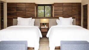 Ein Doppelzimmer mit zwei Betten, einem Nachttisch und einem Fenster.