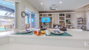 A spacious living area with a television, seating, and a view of the outdoors.