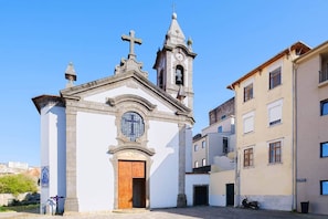 A church with a bell tower and a clock. - NEW! Cozy Studio, 2 min walk to Douro River, w/AC (Vila Nova de Gaia)
