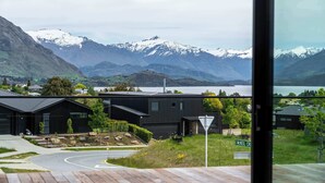 Une maison moderne offrant une vue sur des montagnes enneigées et un lac.