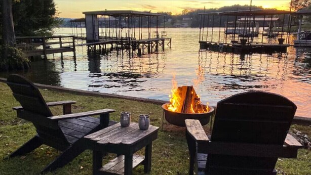 A lakeside view with a fire pit and wooden chairs. - The Lake House at Sunset Bay (Hot Springs)