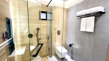 Un baño moderno con ducha de vidrio, inodoro y barra para toallas.