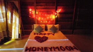 A bed with a heart-shaped arrangement of flowers and the words "HONEYMOON" spelled out on the bedspread. - Dolubari Eco Resort Sreemangal (Kamalganj)