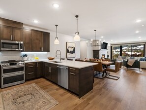 Une cuisine moderne avec des meubles en bois foncé, des appareils électroménagers en acier inoxydable et un grand îlot central.