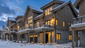 Un immeuble en bois à plusieurs étages, agrémenté d’éléments en pierre, de balcons et de grandes fenêtres.