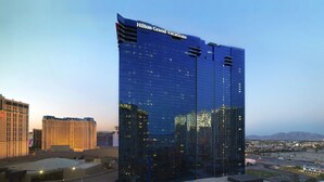 Un hôtel moderne de grande hauteur, dont la façade porte l’inscription « Hilton Grand Vacations ».