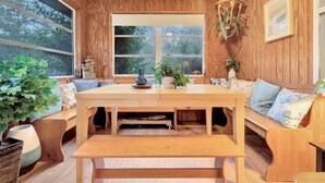 A wooden interior with a large window, wooden furniture, and potted plants. - Bnb Hyperion 4B2B Home w Firepit, Hot Tub & Pond (Eustis)