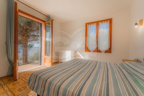 Ein Schlafzimmer mit einem großen Bett, einem Schminktisch und einem Fenster mit Vorhängen.