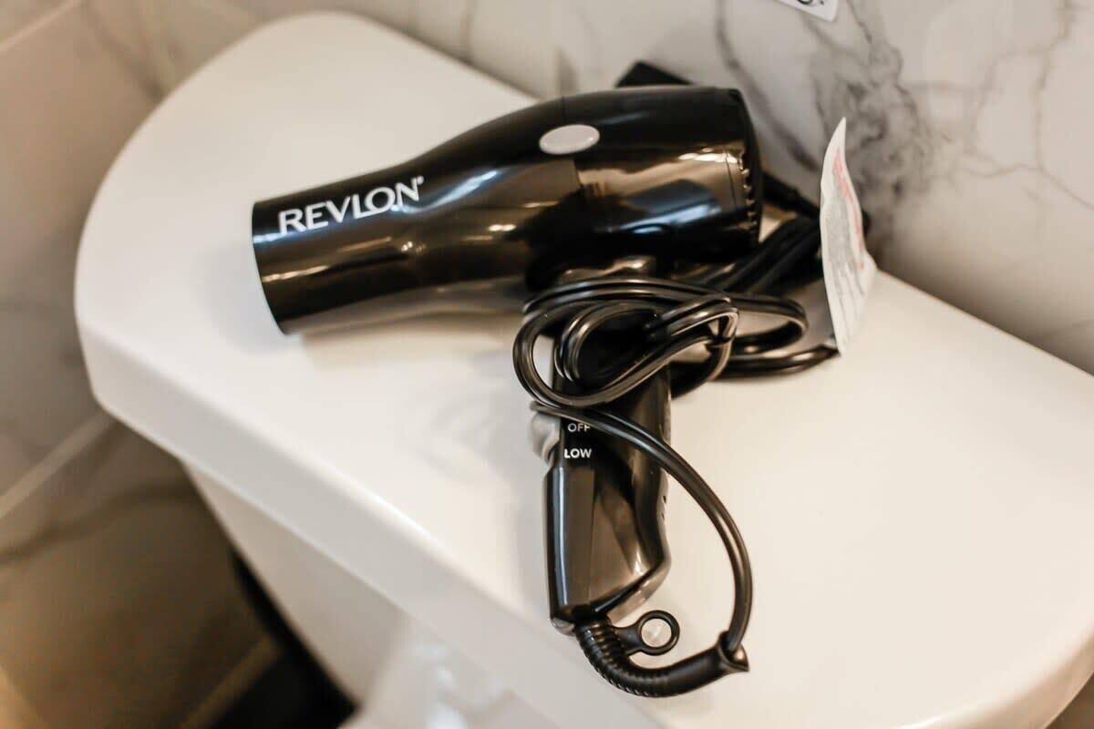 Ein Revlon Haartrockner steht auf einer weißen Waschtischplatte.