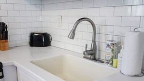 Eine Küchenspüle mit modernem Wasserhahn, ein Toaster und eine Flasche Meyer Lemon Handseife.