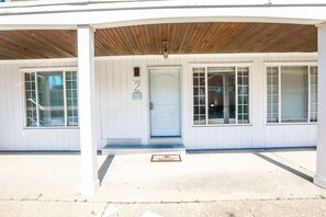 A building with a covered entrance, a door marked with the number 2, and a welcome mat. - Sojourn Tide Suite 2 BR 2 BA at Beach Cottages #2 (Norfolk)