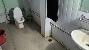 A small, basic bathroom with a toilet, sink, and a shower area. - Angel Eco Resort & Restaurant Cox'sBazar (Cox's Bazar)