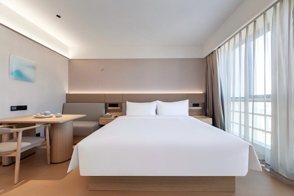 Una habitación de hotel moderna con una cama grande, un escritorio y una silla.
