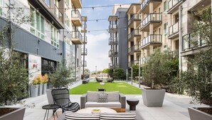 A modern apartment complex with balconies, outdoor seating, and a well-maintained lawn. - Clean Cozy and Calm Retreat (Glendale)