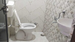 Un bagno con il water, un lavandino e pareti rivestite di piastrelle.