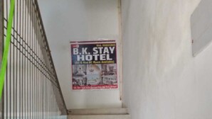 Una scala conduce a un Hotel B.K. Stay, con un cartello pubblicitario che offre camere con e senza aria condizionata.