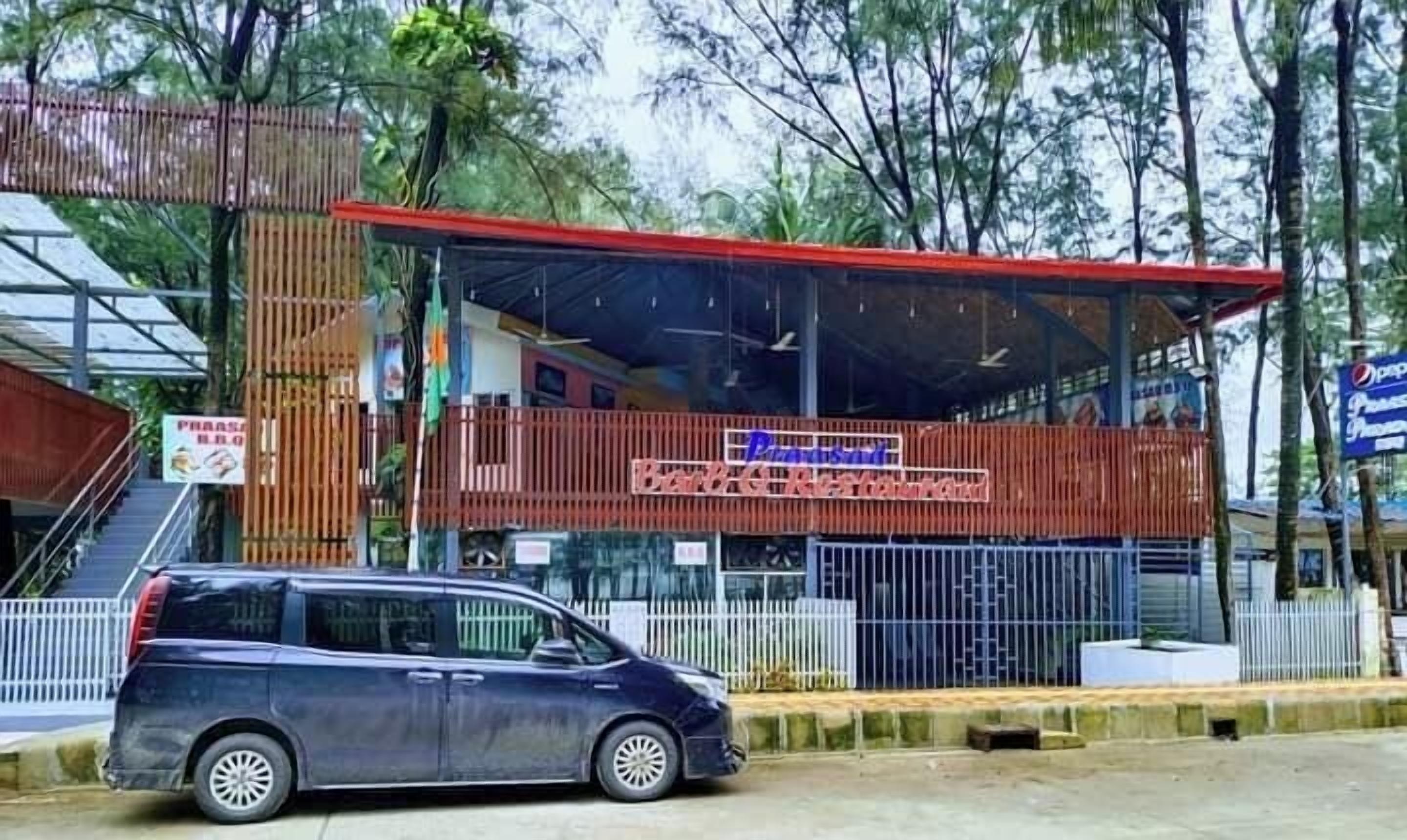 Un edificio con techo rojo y un letrero que dice 'Pension Baranggay'.