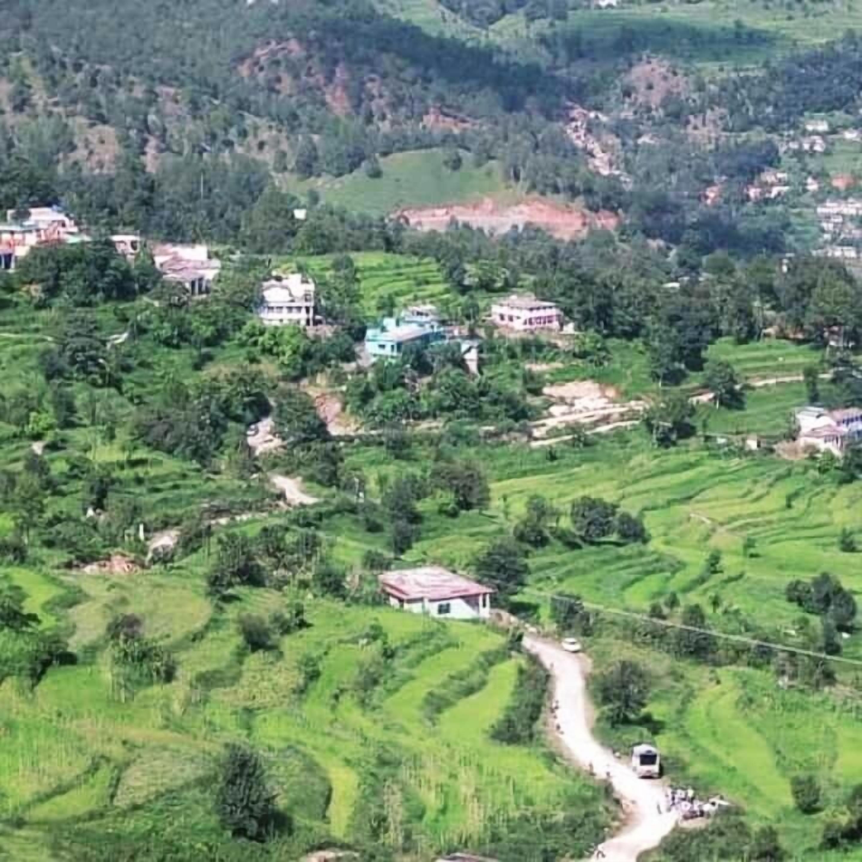 Paisaje rural con campos en terrazas y edificios dispersos.