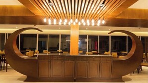 A modern reception area with a central pillar, wooden slats on the ceiling, and a curved counter. - Royal Pearl Apartment&Suites Cox's Bazar (Cox's Bazar)