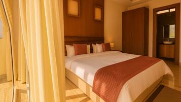 A hotel room with a large bed, wooden headboard, and a bathroom with a sink and mirror.