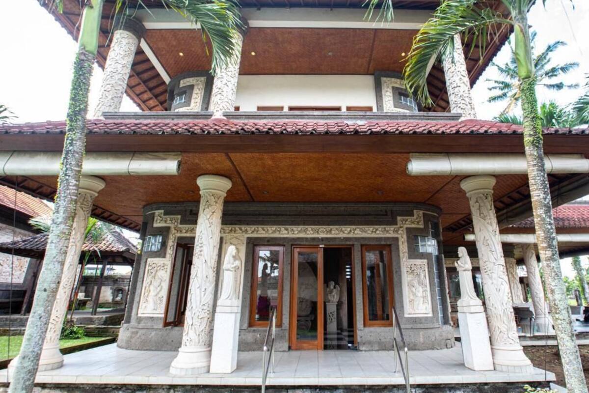 A building with a covered entrance, columns, and a tiled roof.