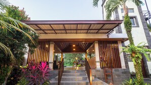 A covered outdoor staircase leading to a building entrance, surrounded by lush greenery and a lantern. - Awatara Villas and Resort Ubud (Kemenuh)