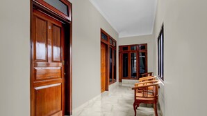 A hallway with wooden doors and a marble floor. - OYO 94920 House Of Elea Minggiran (Yogyakarta)