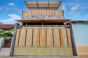 Ein zweistöckiges Gebäude mit einem Balkon und einem großen Holztor.
