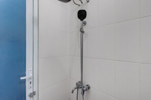Deluxe tweepersoonskamer | Badkamer | Een douche, handdoeken, zeep, toiletpapier