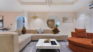 Una sala moderna con un sofá modular, una mesa de centro y un espejo redondo.
