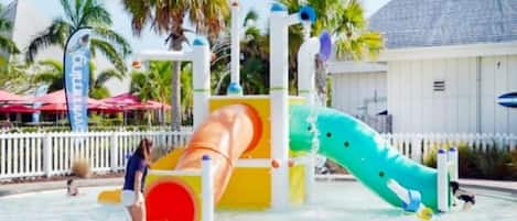Parque acuático con tobogán y zona de juegos con agua.