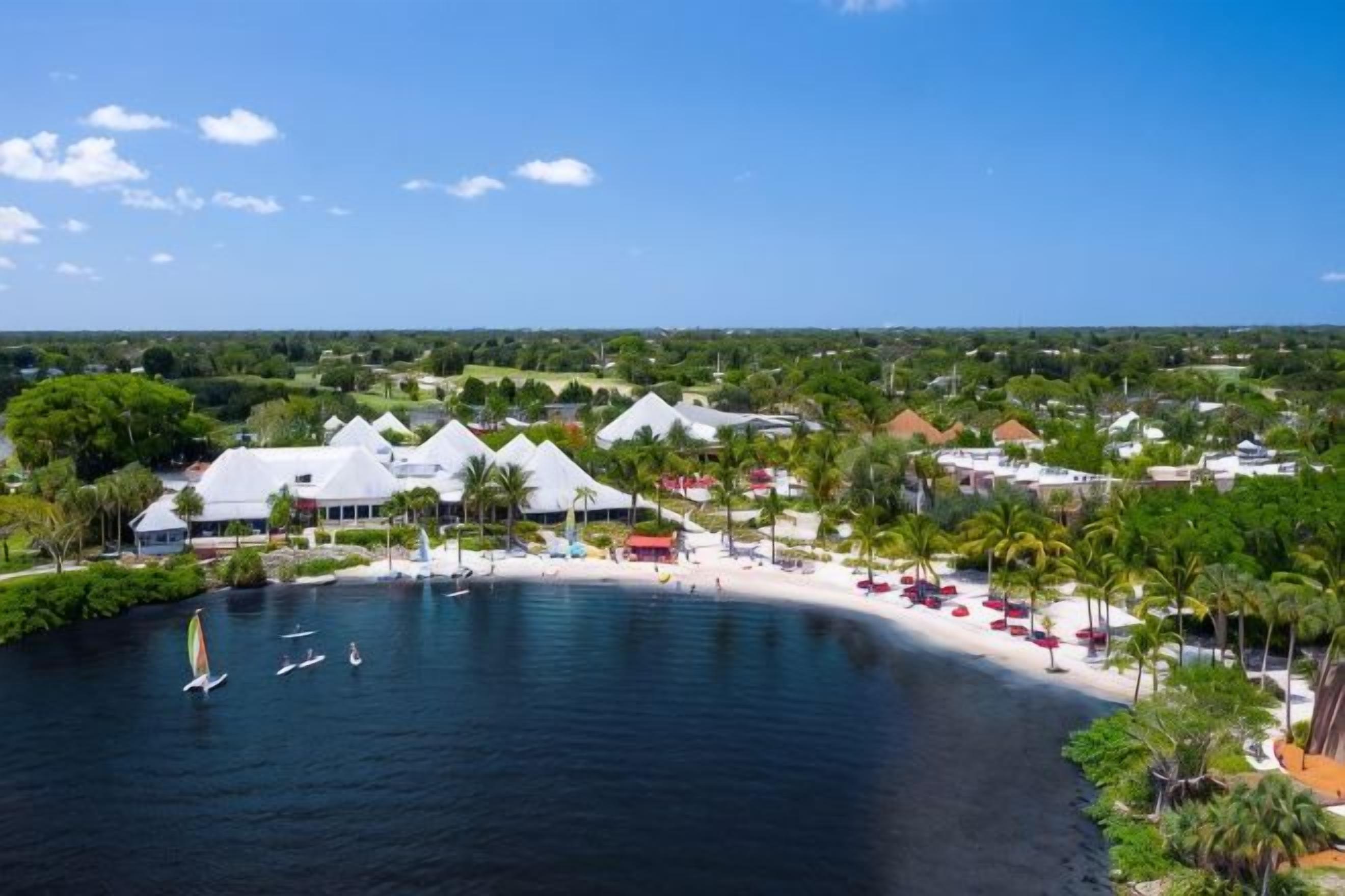 A coastal resort with beachfront villas, a sandy beach, and a marina.