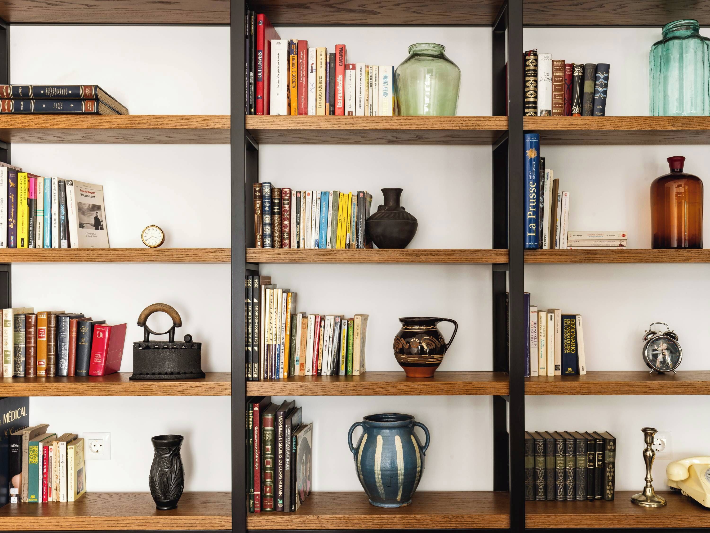 Une bibliothèque contenant divers livres et objets décoratifs.
