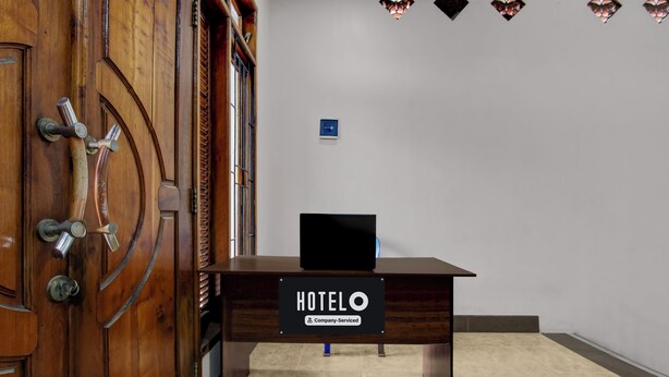 A hotel reception desk with a sign indicating it is company-serviced. - OYO 94935 Rahayu Homestay (Mangunan)